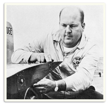 photo of Bob Osiecki inspecting the wing of the Mad Dog IV racecar