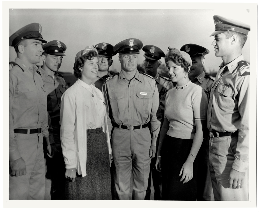 Two women and seven men standing in a group. The men are wearing Air Force uniforms and the women are wearing rat caps