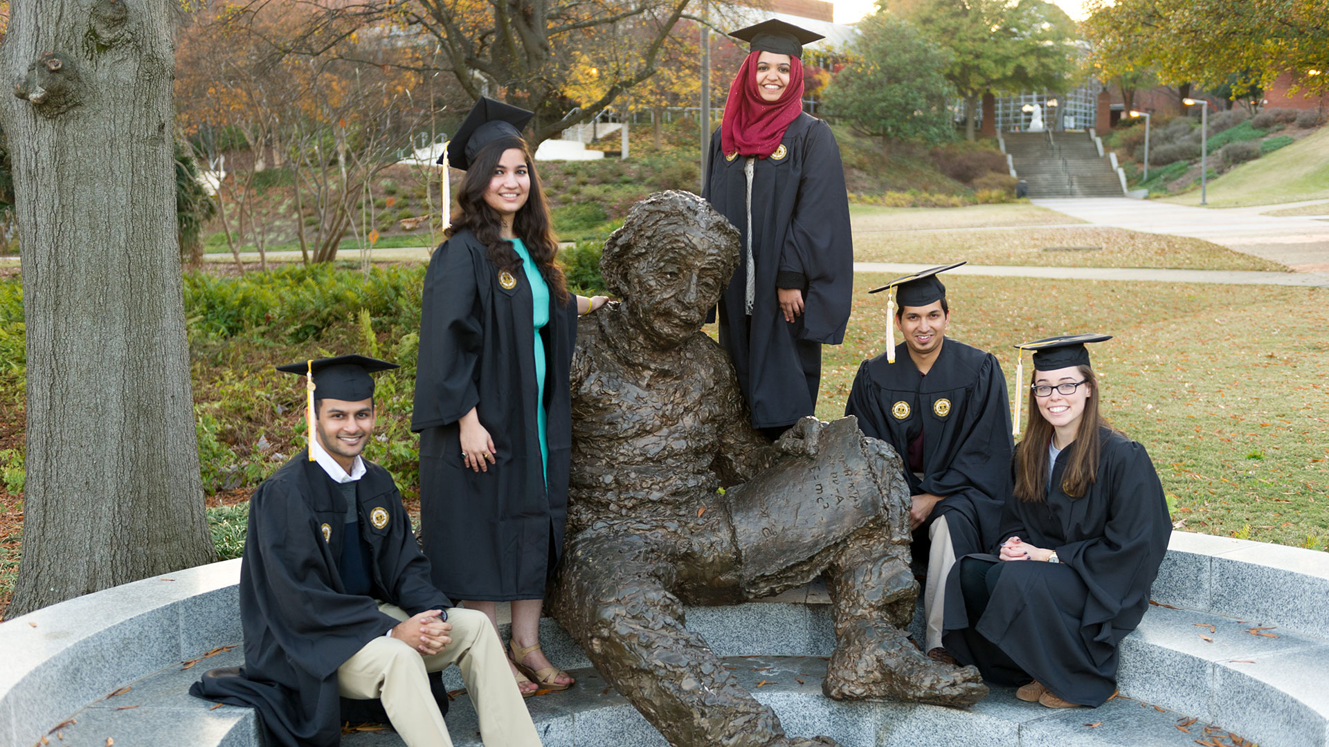 photo: students sitting, and standing on, steps of Einstein statue