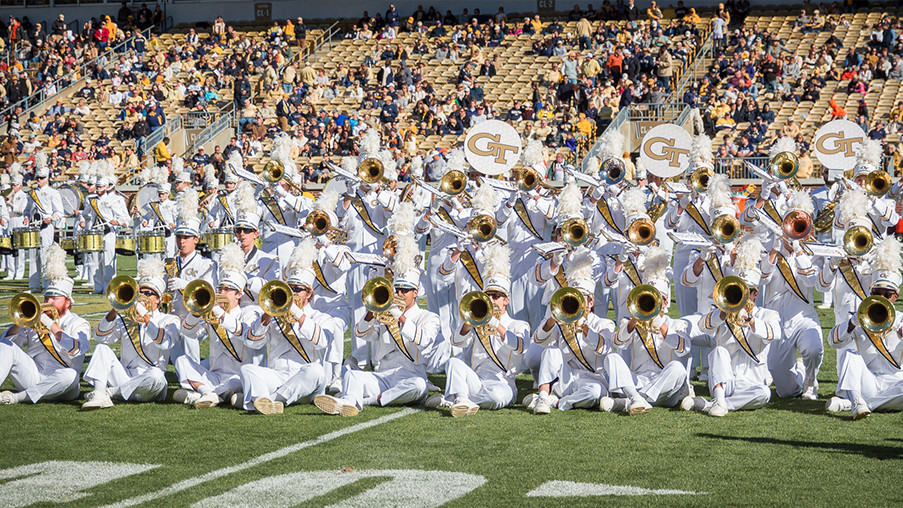 The Georgia Tech marching band sits on the field to play a few notes during a halftime show.