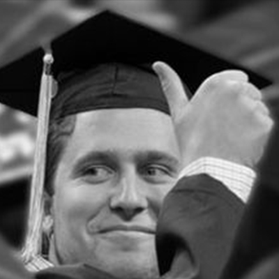 A male graduate giving the thumbs up.