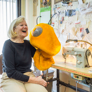 Kathy Spetz in her sewing room, holds up the head of Georgia Tech's mascot, Buzz.