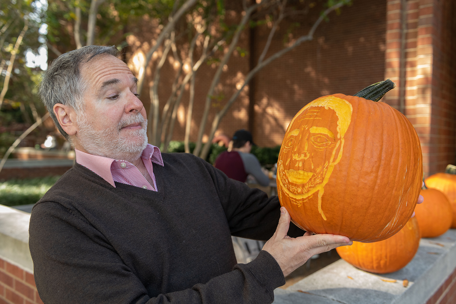 Andrew Zangwill, a professor in the School of Physics, holds a pumpkin of his likeness. 