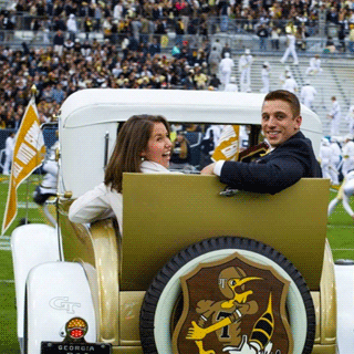 Mr and Ms Georgia Tech smile from the back of the Rambin Wreck during the Homecoming game.