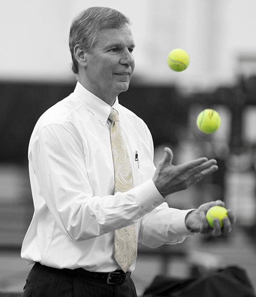 President Peterson juggles tennis balls at the Ken Byers Tennis Complex.