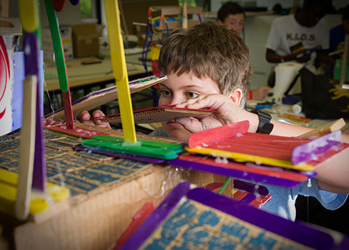 A young camper works on a project during summer camp.