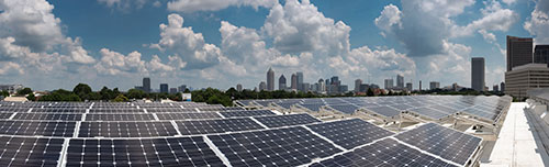 Atlanta skyline peeps from behind solar panels on the roof of the CNES building