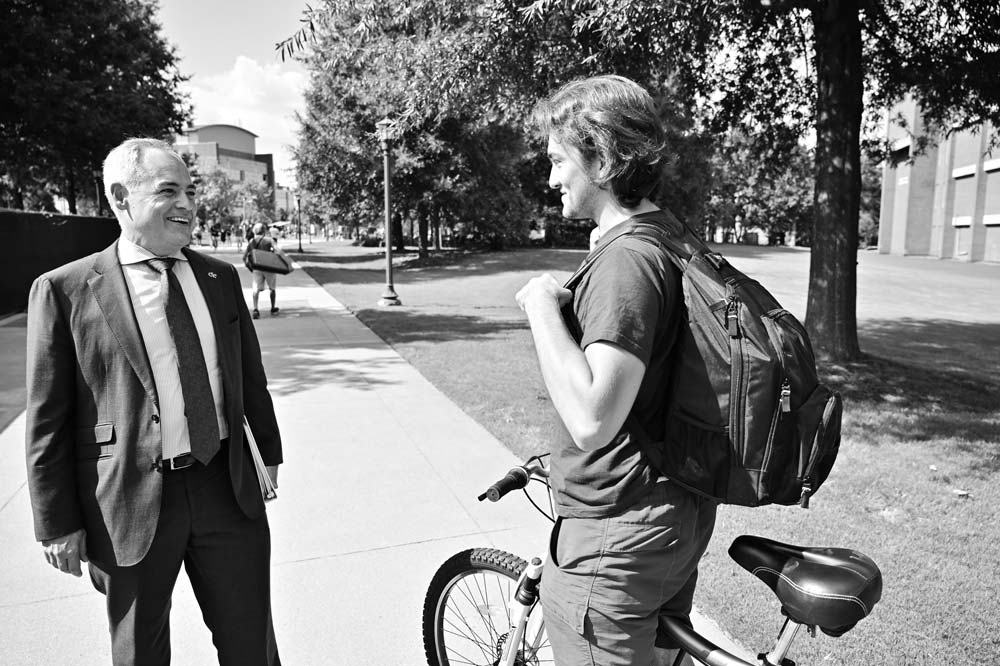 Student on a bicycle stopped to talk to President Cabrera
