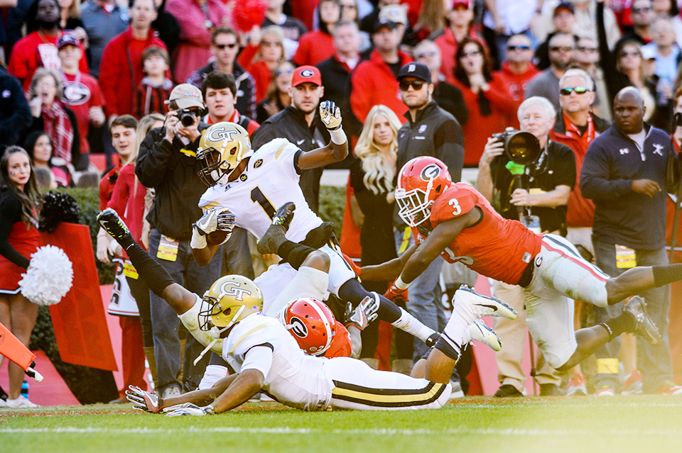 Qua Searcy carrying the ball during a play with a Georgia defender leaping toward him