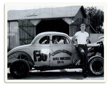 Driver Tommy Smith leans on the Causey 1936 Oldsmobile.