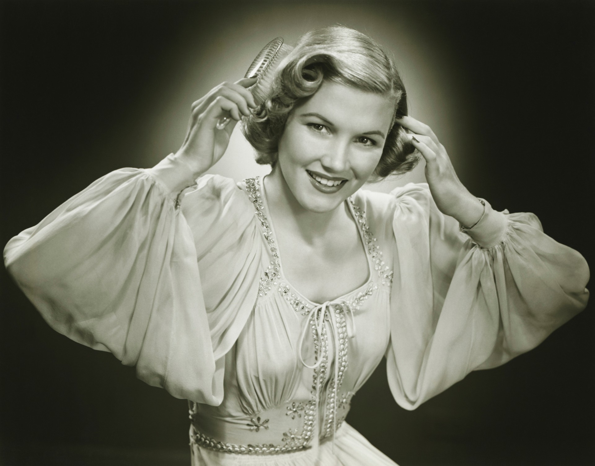 Vintage photo of a woman combing curly hair