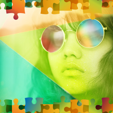 A young child wearing mirrored sunglasses which reflect the prism all around her.