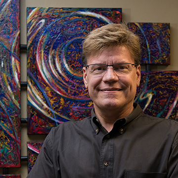 bobby strickland in front of his art