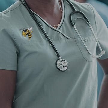 A nurse with a stethoscope and Georgia Tech's Buzz emblem.