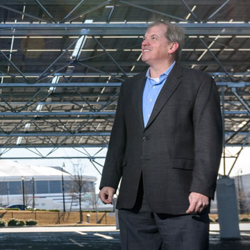 Norman “Finn” Findley stands beneath a canopy of shiny solar panels that covers a parking lot adjacent to what will be Atlanta’s new football stadium.