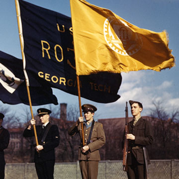 ROTC students in uniform, c. 1945, hold flags for ROTC and the Institute, while another student holds a rifle