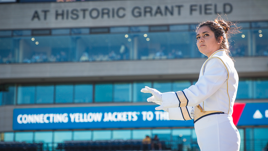 Newest drum major Ariana Olalde leads the Georgia Tech marching band during a halftime show in Bobby Dodd Stadium. 