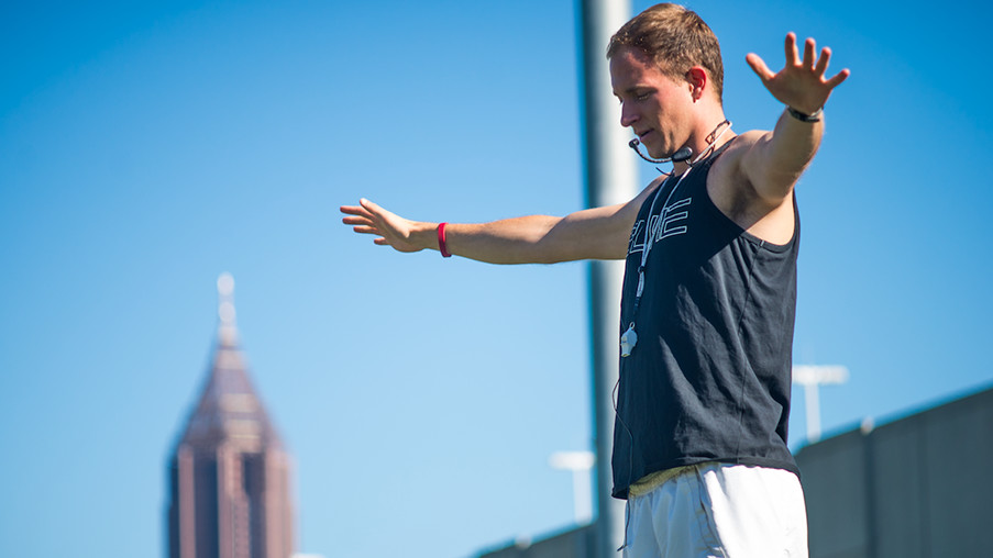 Drum major and fifth year engineering student Parker Buntin directs the Georgia Tech marching band from a podium during a practice session.