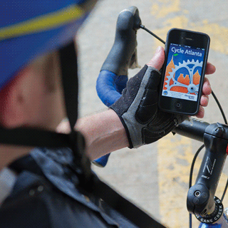 A cyclist holds a smart phone and the Georgia Tech-developed app, "Cycle Atlanta."