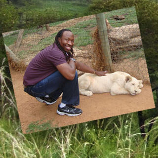 Manu Platt pets a white lion in Africa.
