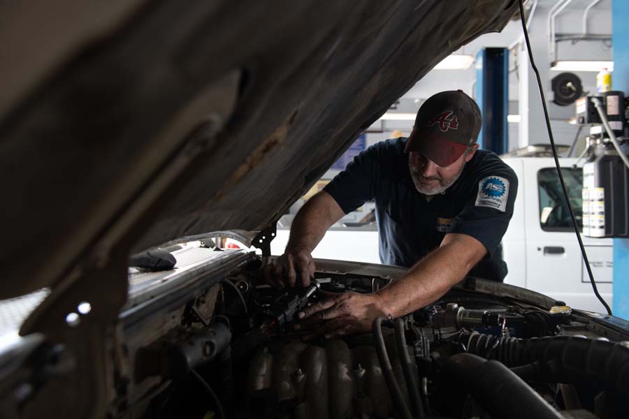 Glenn Byrd, ASE-certified automotive mechanic, performs a tune-up on a Facilities truck.