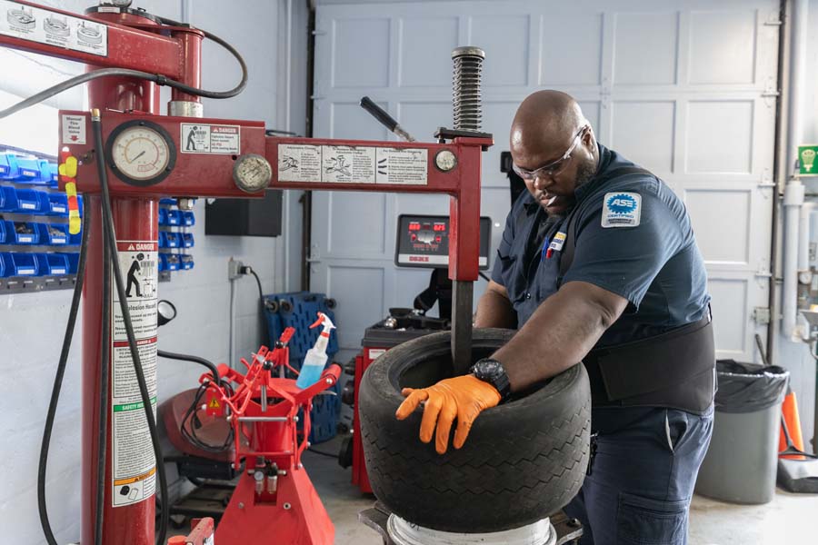 John Horne, ASE-certified mechanic, removes the rim from a tire.