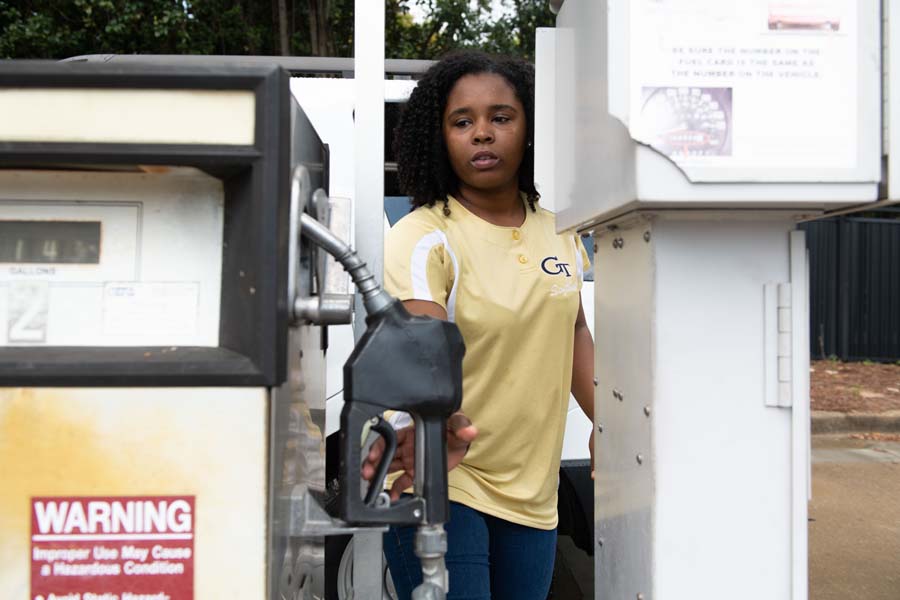 Student worker and business major Imani Burns keeps track of fuel records. Here, she’s refilling a vehicle.