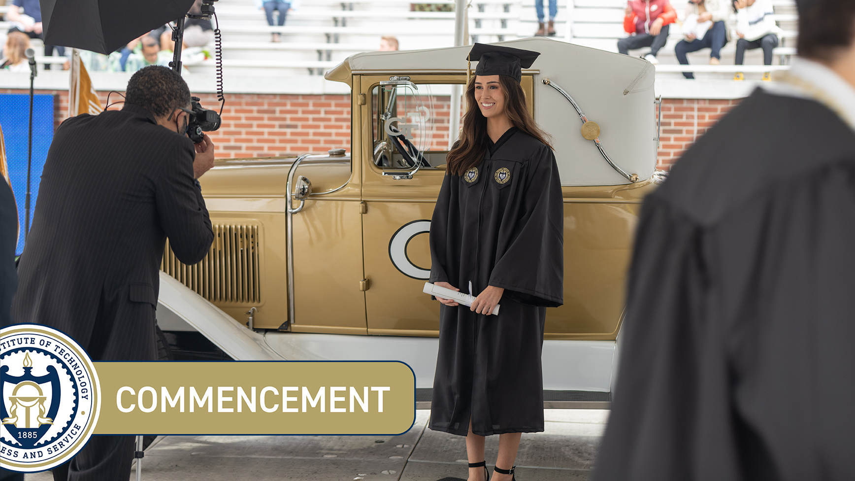 A graduate poses with the Ramblin' Wreck at Fall 2021 Commencement