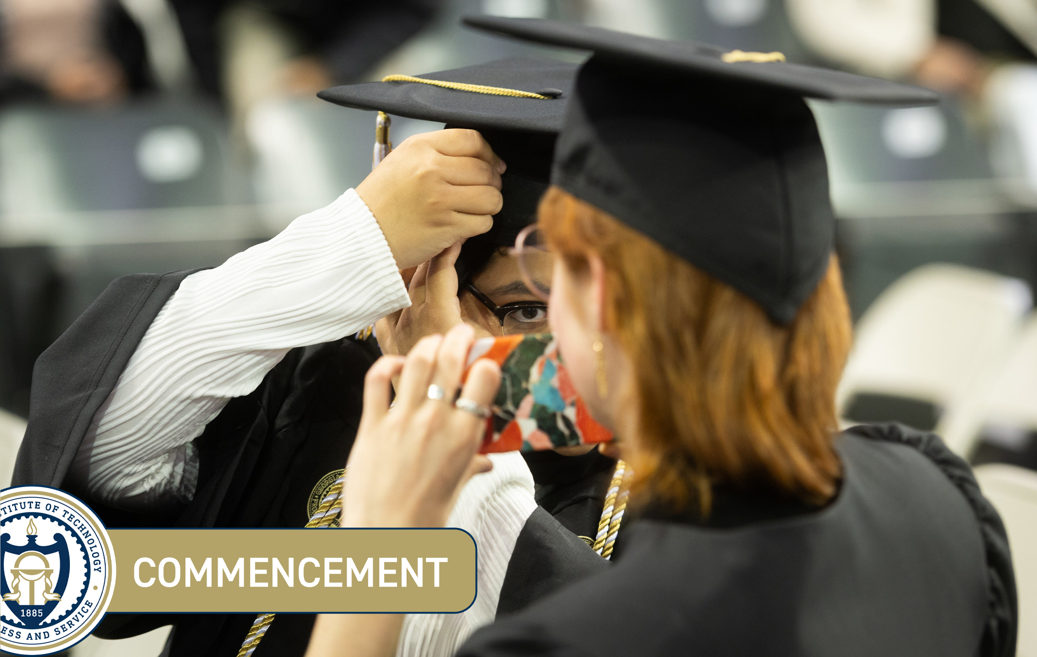 A student adjusts their mortar board at Commencement