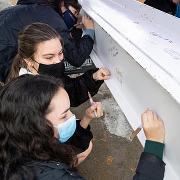 students sign student center beam