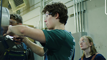 Students working in a lab on top of a gold pattern