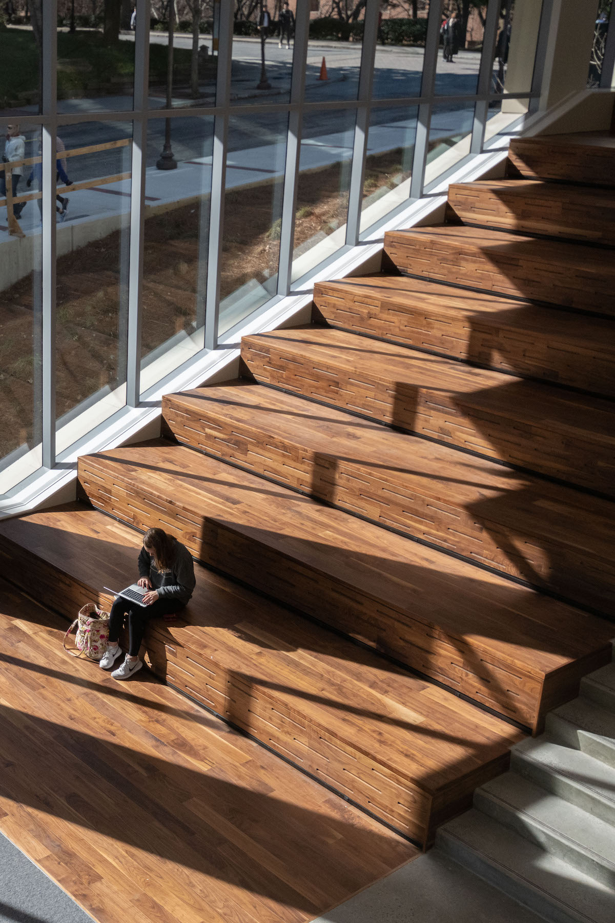 A student with her laptop on the steps of Crosland Tower.