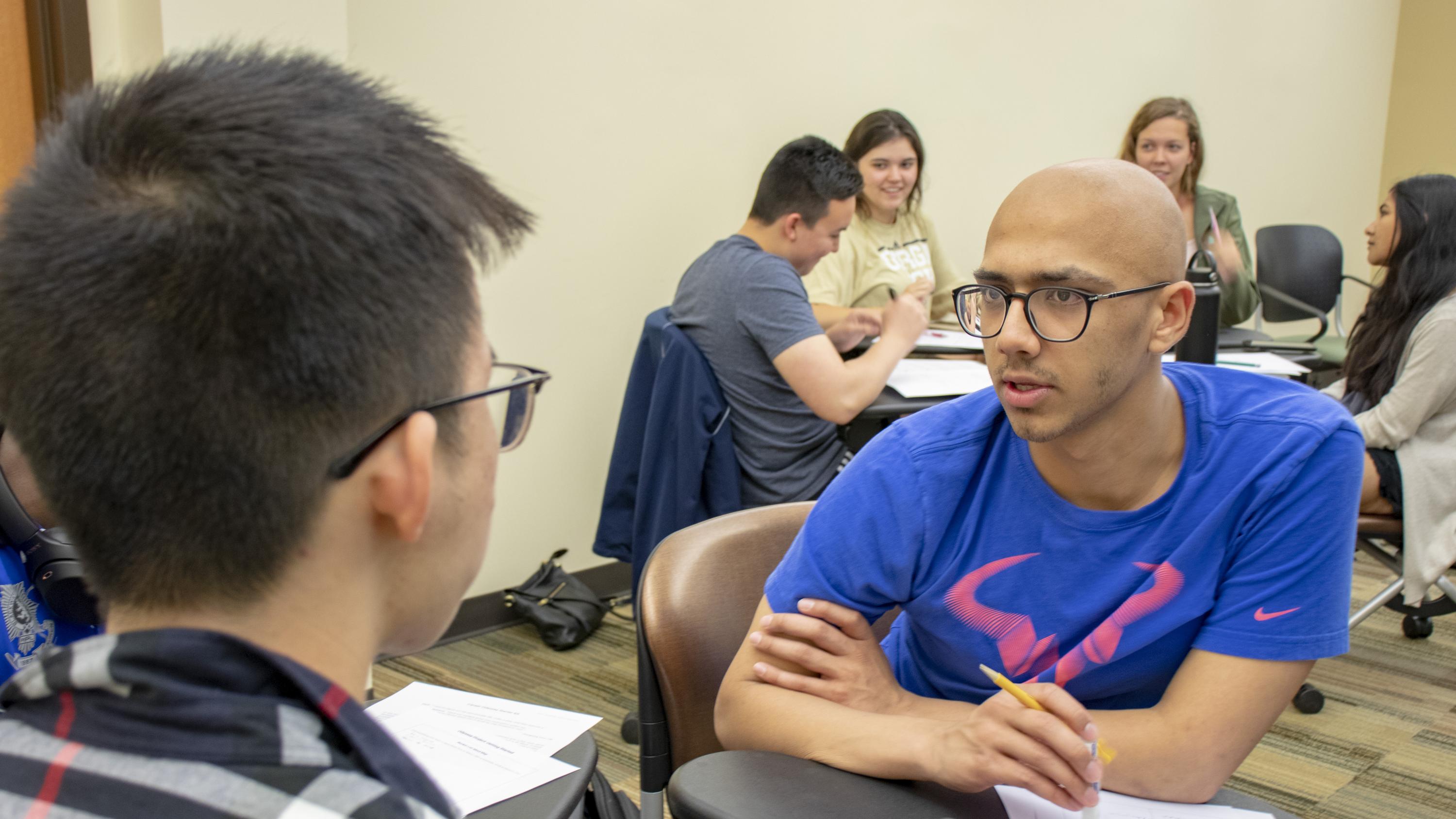 Student Jeremy Hua, left, brainstorms with Shovan Bhatia about their goals for the next 10 years during the April 17, 2019 session of Career Design for Global Citizenship. In the background, students Ian Bunker, Jaynie Rice, Caitlyn Beals, and Sabirah Haque discuss their final project, in which students design several alternative life paths.