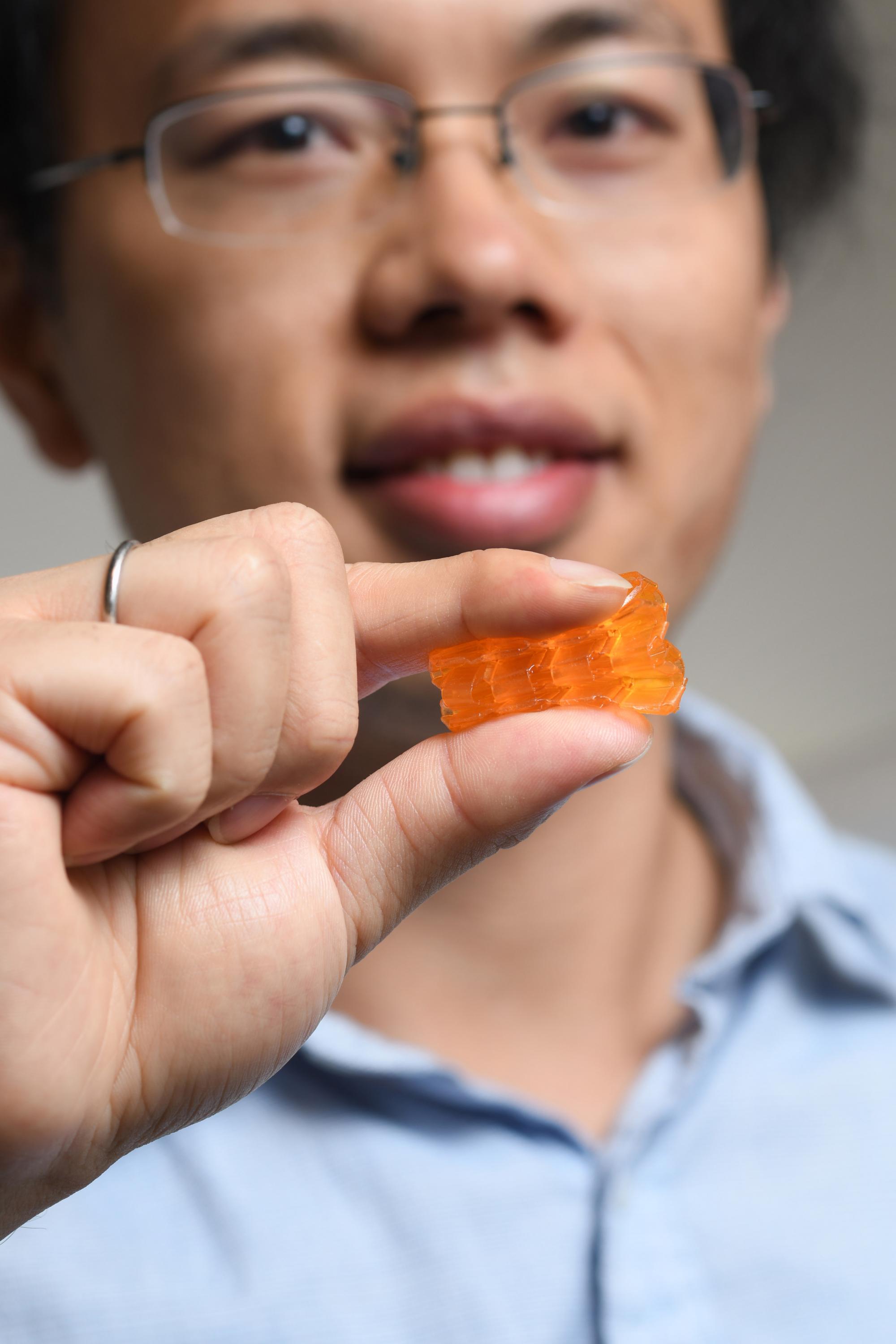 Georgia Tech postdoctoral fellow Xiao Kuang demonstrates the compressibility of origami structures created through Digital Light Processing 3D printing. (Credit: Christopher Moore, Georgia Tech).