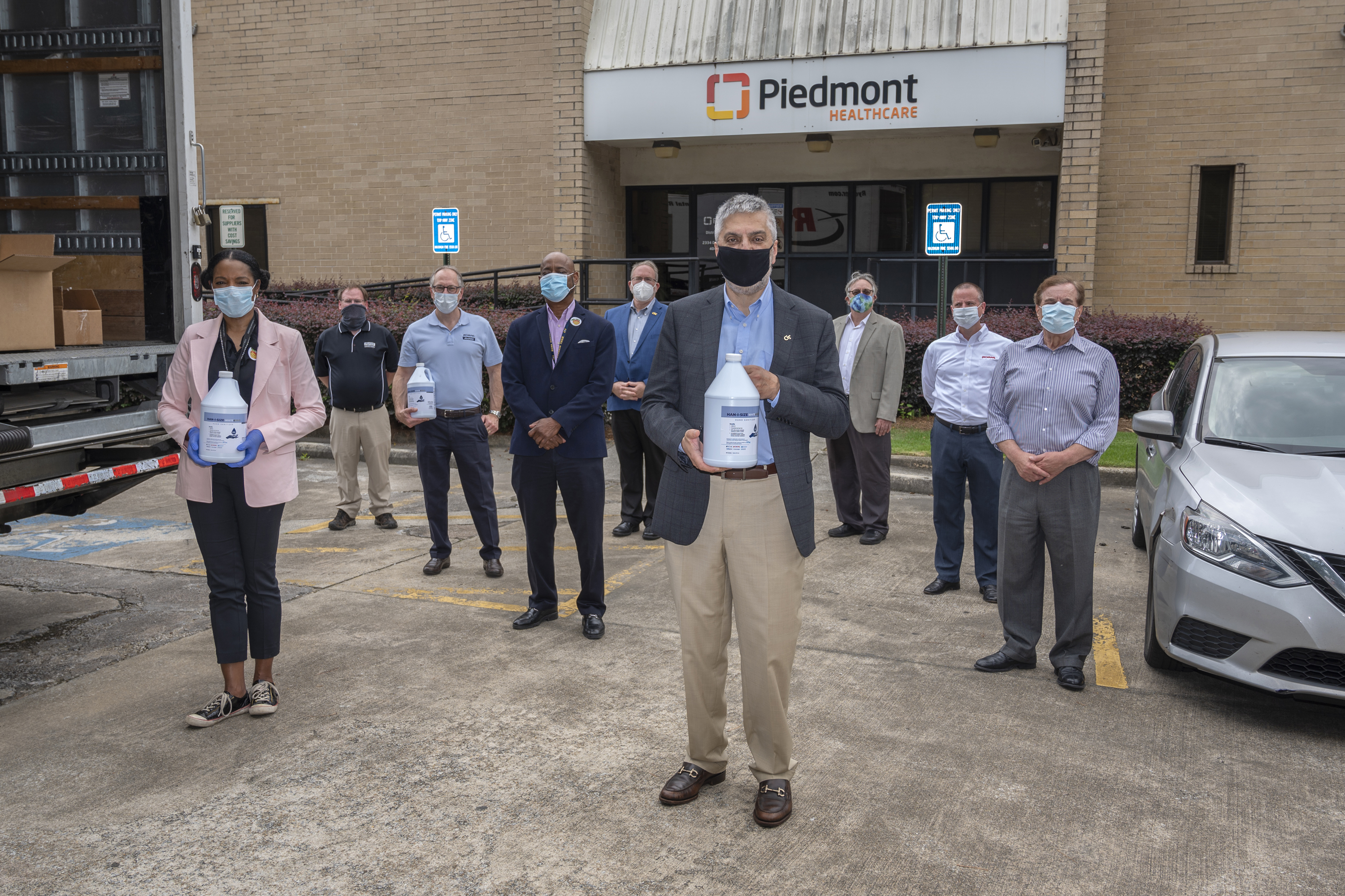Here, many participants in the effort that re-made hand sanitizer using fuel-grade ethanol on its first day of delivery. The volunteers will donate 7,000 gallons of Han-I-Size White and Gold to hospitals and nursing homes across the country. In front, Dr. Chaouki Abdallah, Executive Vice President for Research, congratulates the group on its success.