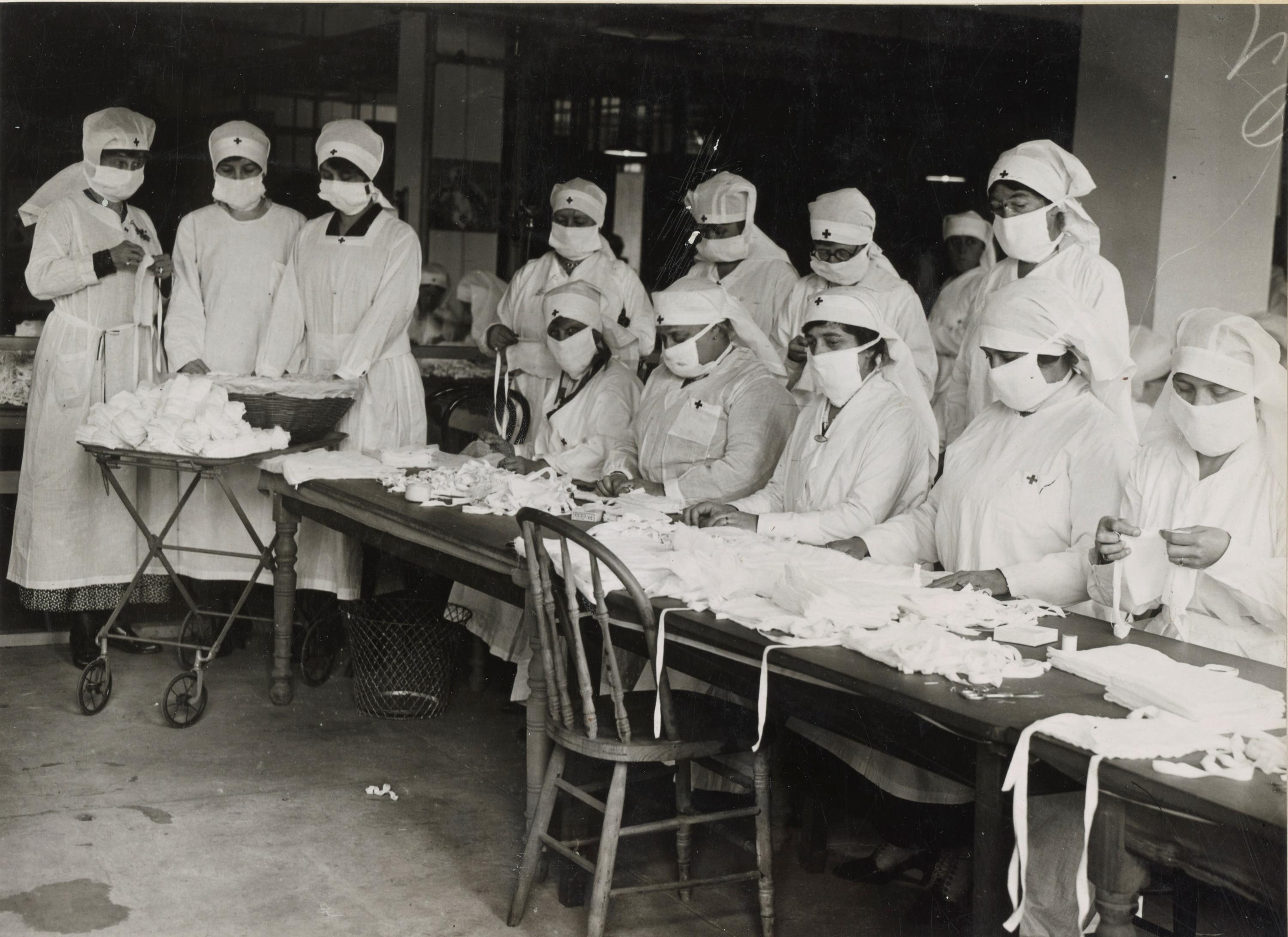 Red Cross workers in Boston, Massachusetts, hand out face masks during the Spanish flu pandemic. Credit: National Archives