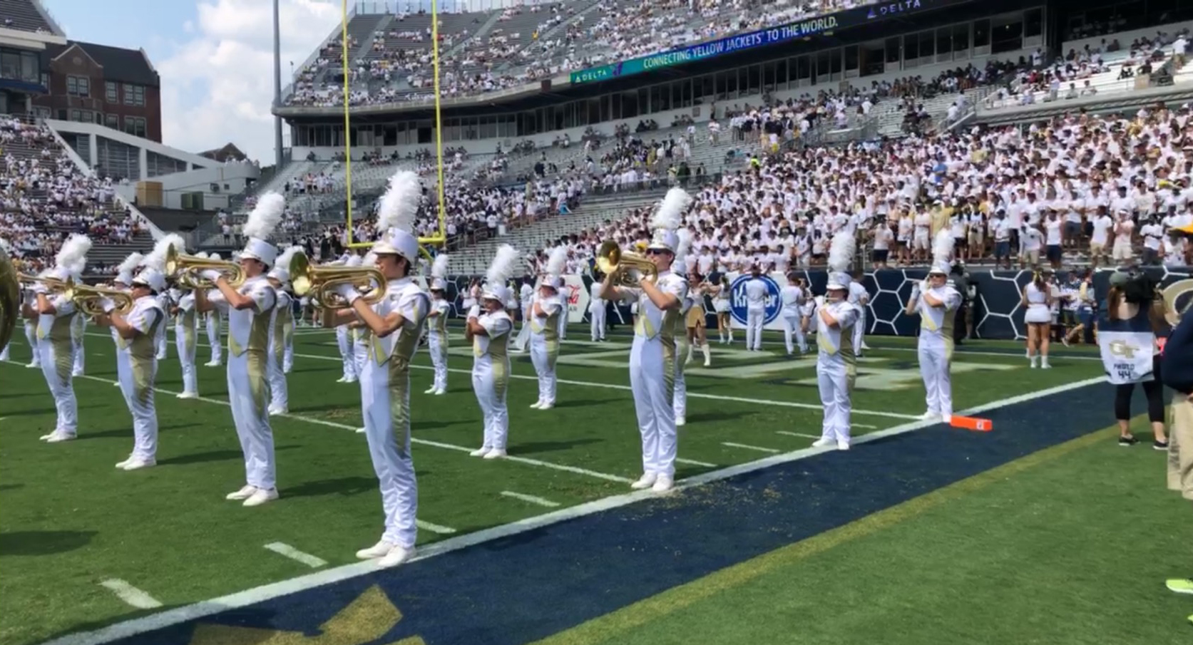 The marching band halts on the field during their pregame performance.