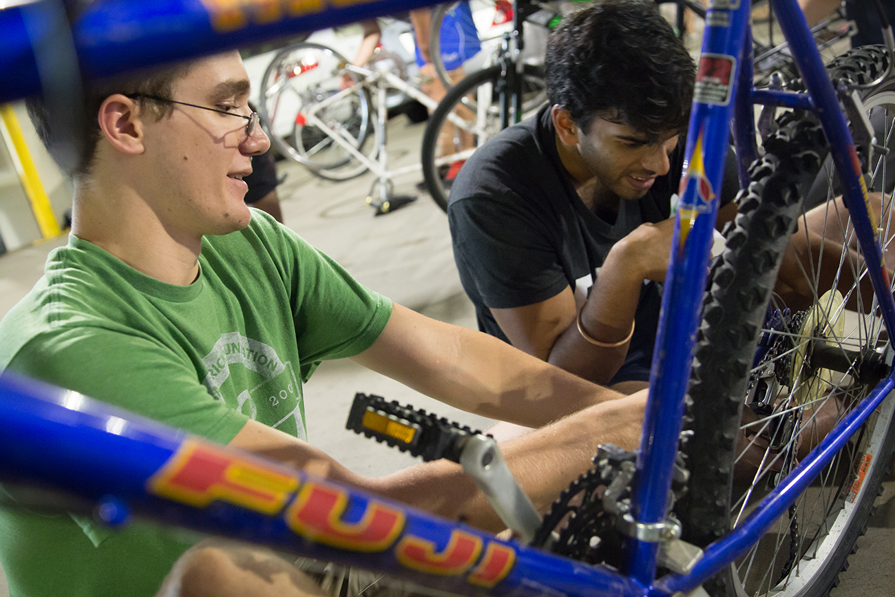 Joseph Robinson (left), an aerospace engineering student, and Arjun Chintapalli, a mechanical engineering student, work on a bike at Starter Bikes in the Campus Recreation Center parking garage. 