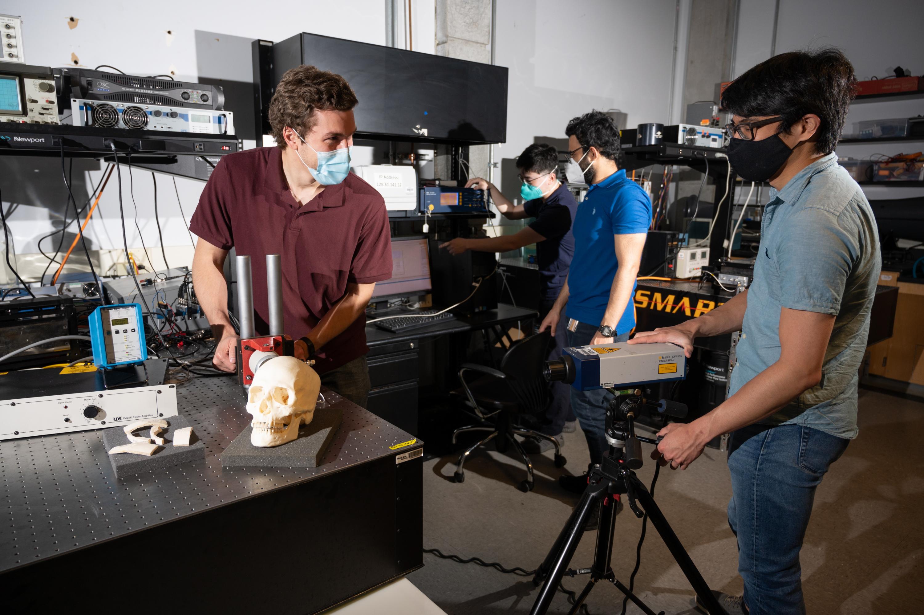 Graduate research assistants Eetu Kohtanen and Pradosh Dash and postdoctoral researchers Christopher Sugino and Bowen Jing test a human skull to measure and characterize its vibration response. (Photo credit: Allison Carter, Georgia Tech)
