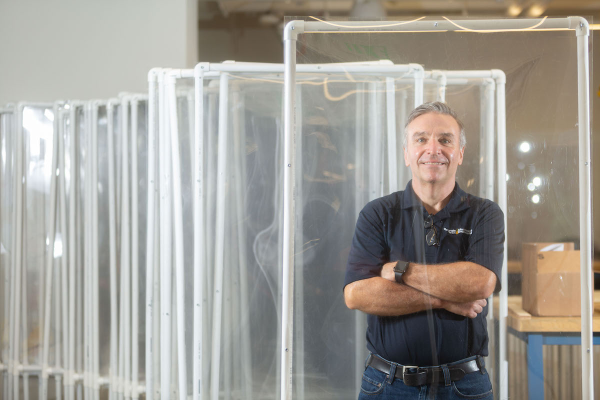 Steven Sheffield and his team have been part of Georgia Tech's response to the coronavirus pandemic. He is pictured behind a protective barrier manufactured at Tech. (Photo by Allison Carter.)