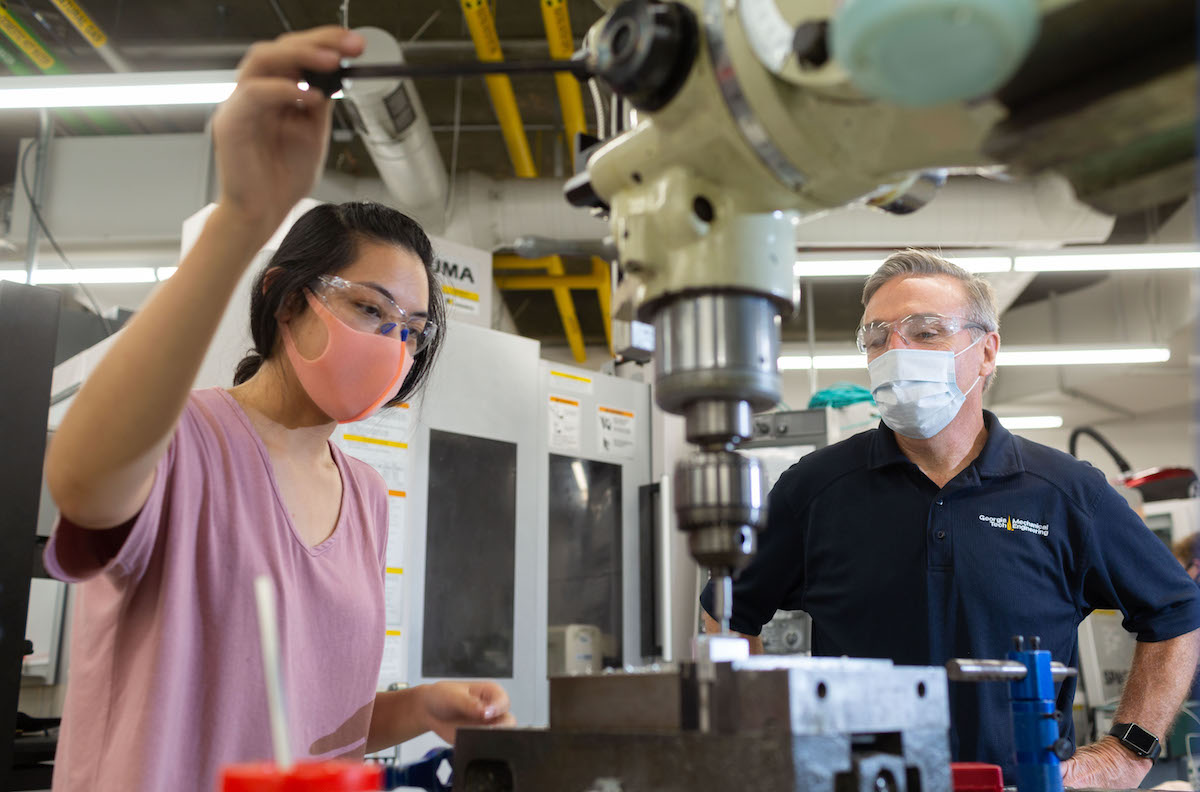 Steven Sheffield, machine shop manager, works with Gwen Wang, mechanical engineering doctoral student, in the Montgomery Machining Mall. (Photo by Allison Carter.)