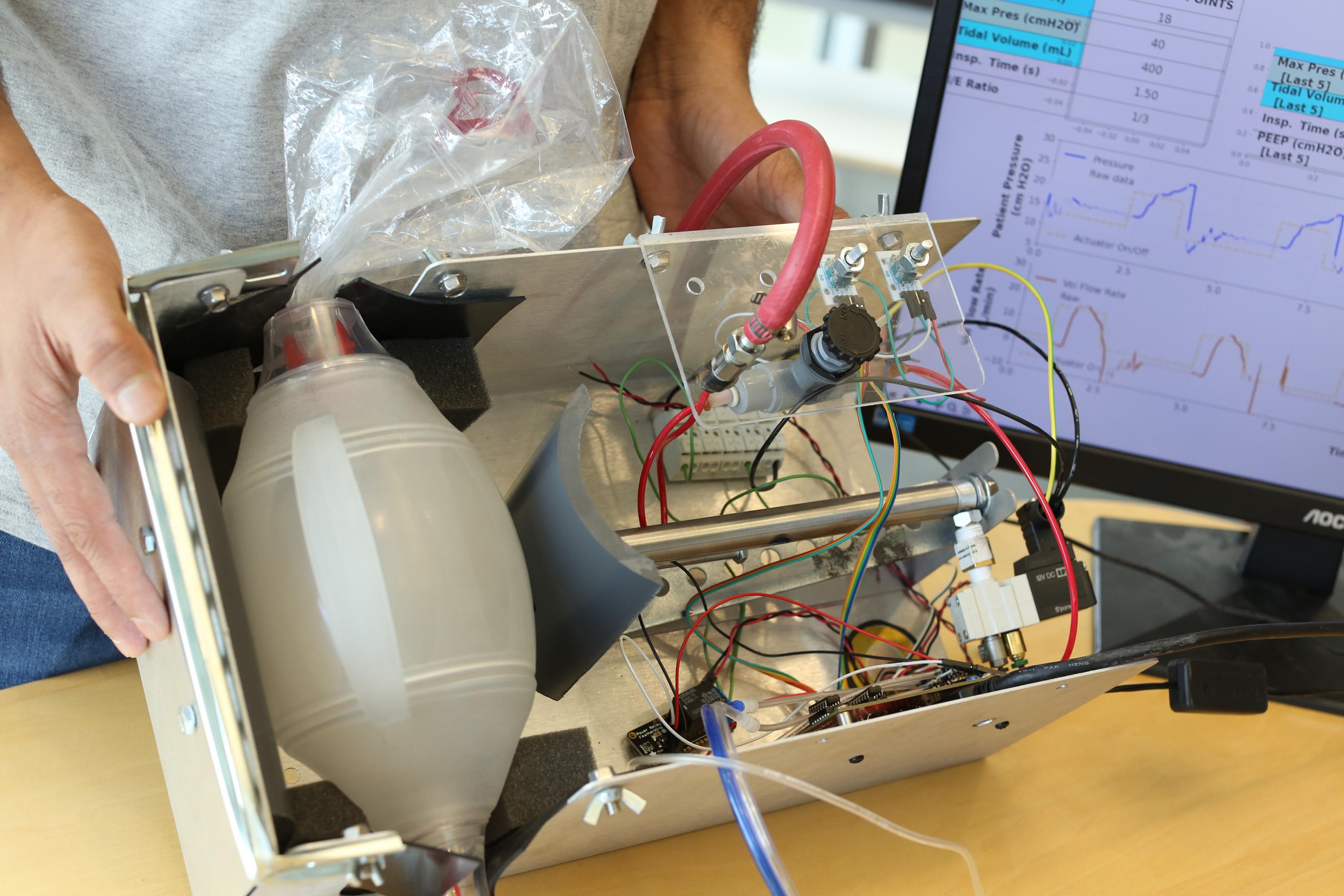 Image shows components of the Open-AirVentGT, a low-cost, portable emergency ventilator that uses electronic sensors and computer control to manage key clinical parameters. From left to right are the BVM resuscitator, the pneumatically-actuated piston, electronics and computer controls. (Credit: Ben Wright, Georgia Tech)