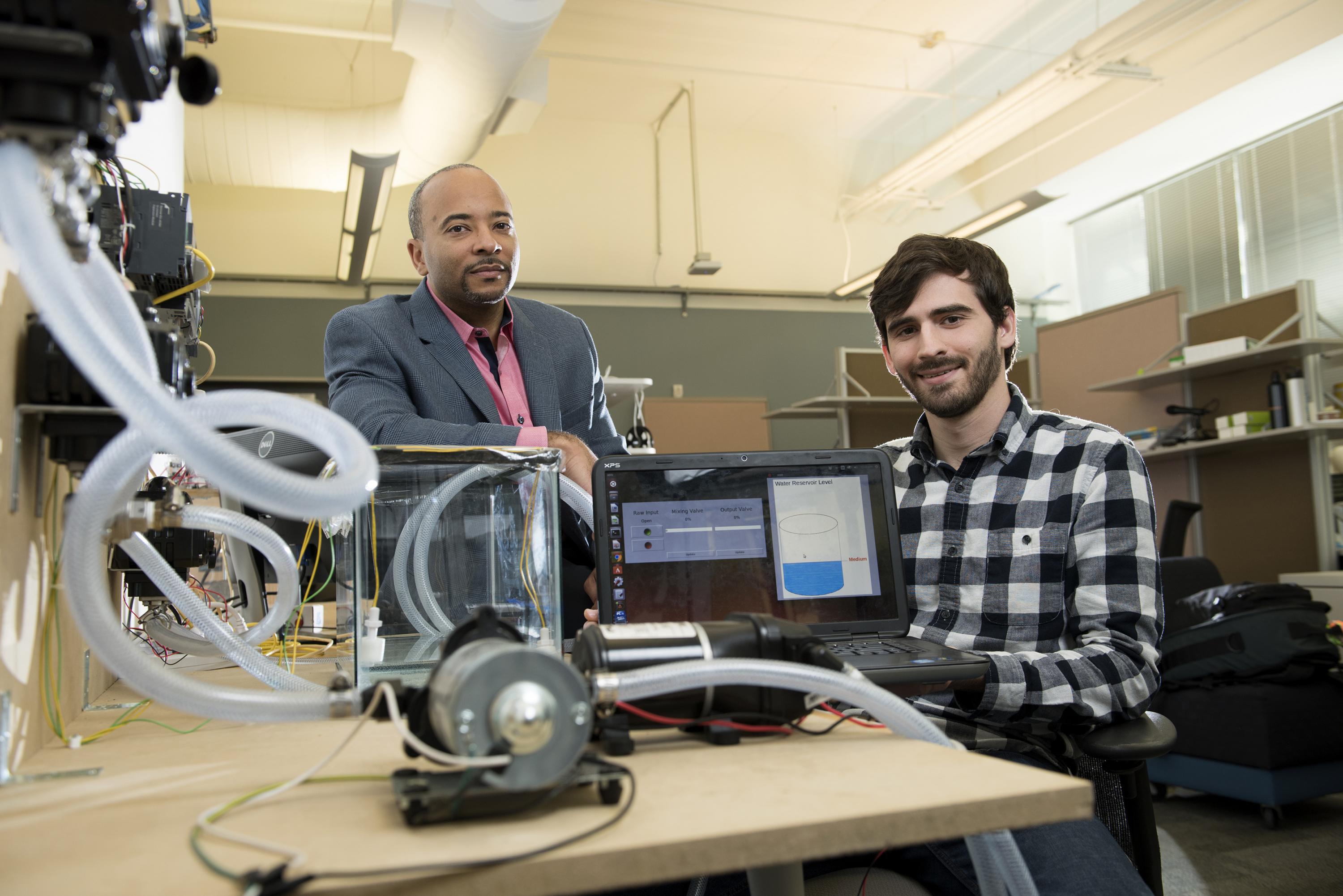 Georgia Tech researchers have developed a new form of ransomware that can take over control of a simulated water treatment plant. The simulated attack was designed to highlight vulnerabilities in the control systems used to operate industrial facilities. Shown are (left) Raheem Beyah, associate chair in the Georgia Tech School of Electrical and Computer Engineering, and David Formby, a Georgia Tech Ph.D. student. (Credit: Christopher Moore, Georgia Tech) 