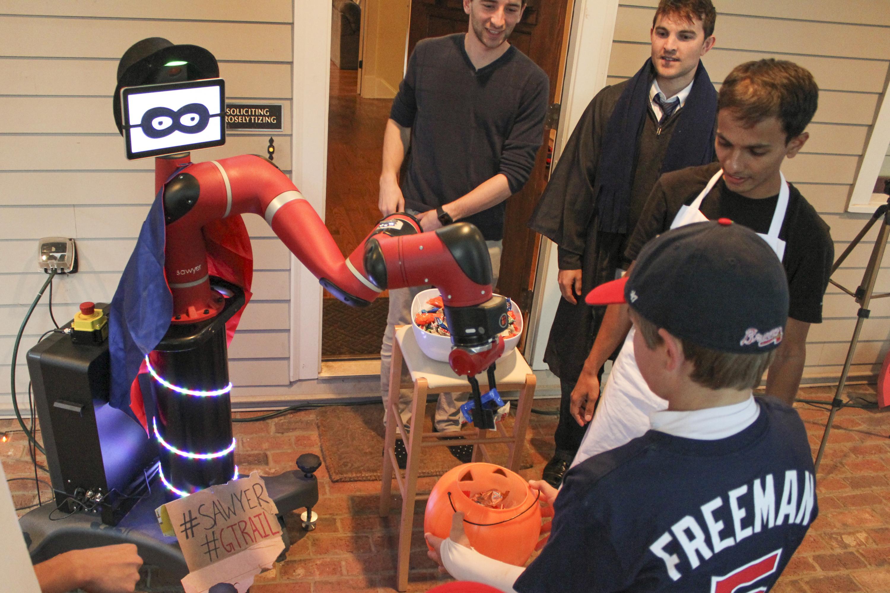 Wearing a mask, cape and hat, Sawyer the robot gives out candy on Halloween.
