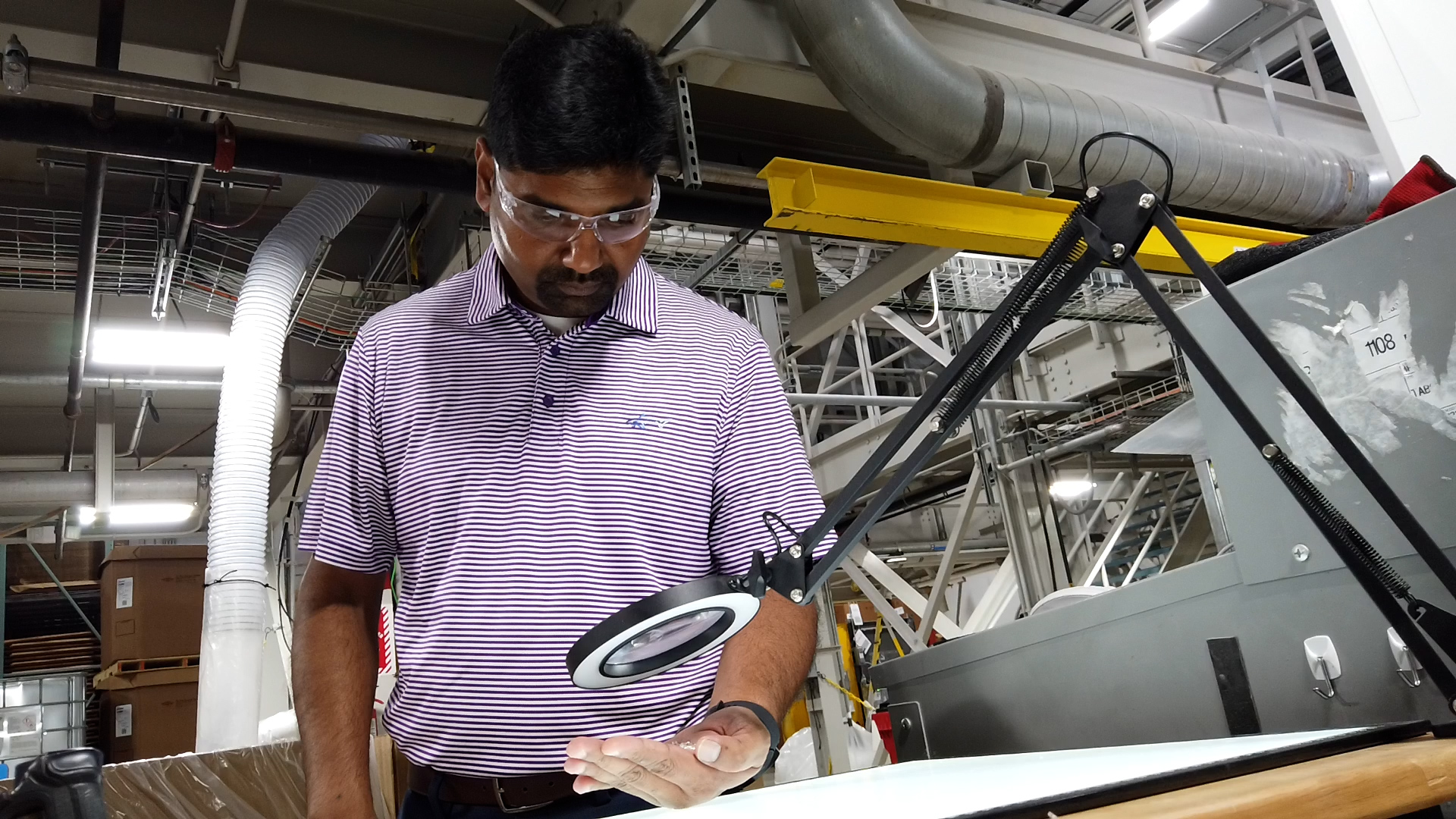 Sean Madhavaraman, a leader at GaMEP, examines work product at Silon in Peachtree City, Georgia