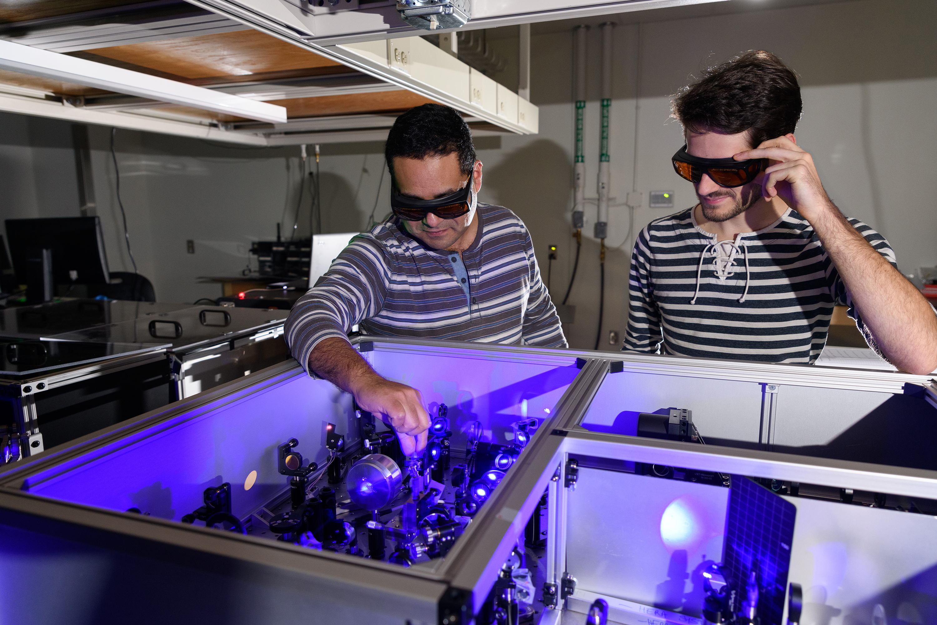 Carlos Silva (l.) in his lab at Georgia Tech with graduate research assistant Félix Thouin examining a setup to process laser light in the visible range for the testing of quantum properties in a halide organic-inorganic perovskite. Georgia Tech / Rob Felt