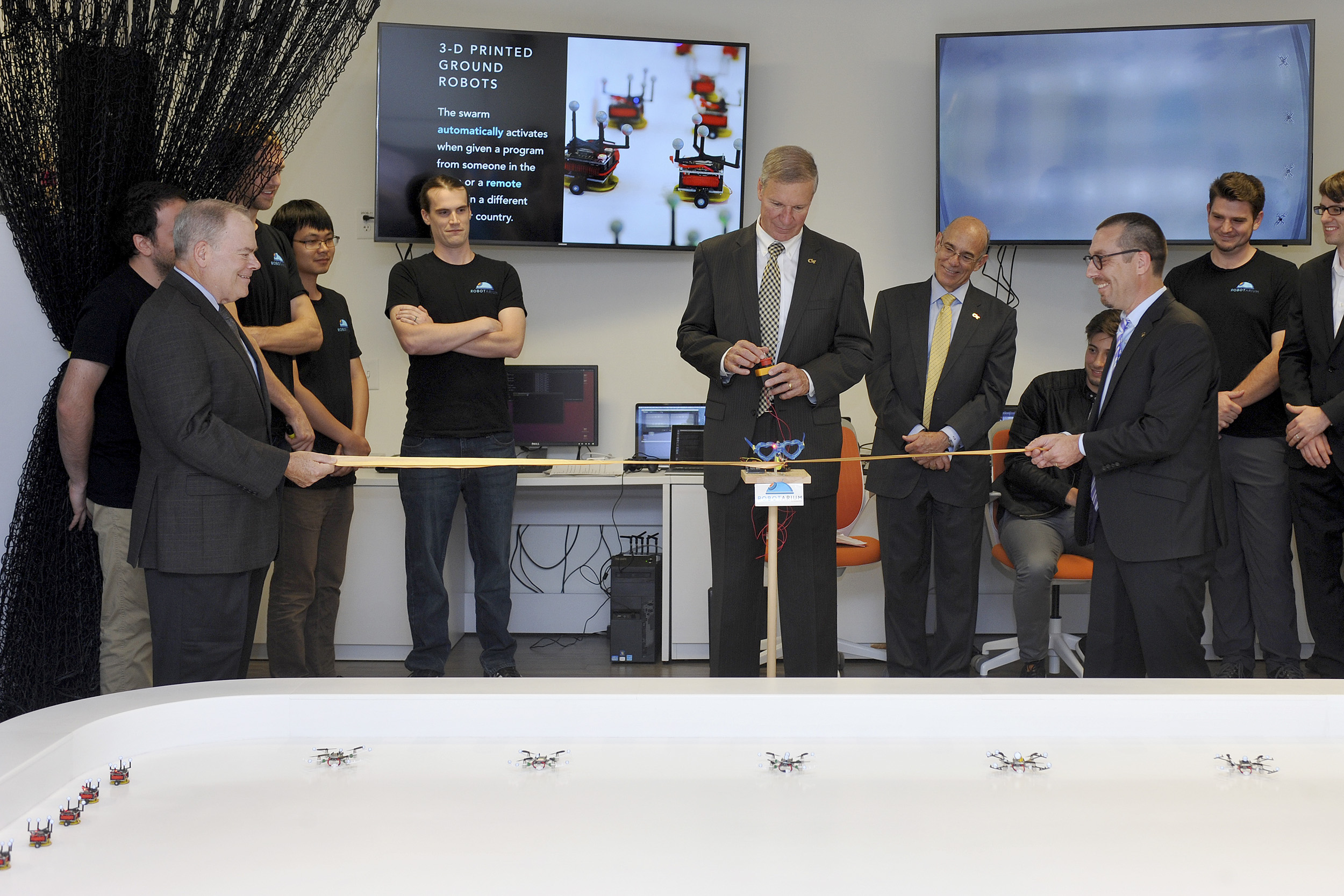 Snips the robot, controlled by President G.P. "Bud" Peterson, cuts the ribbon to open the Robotarium.