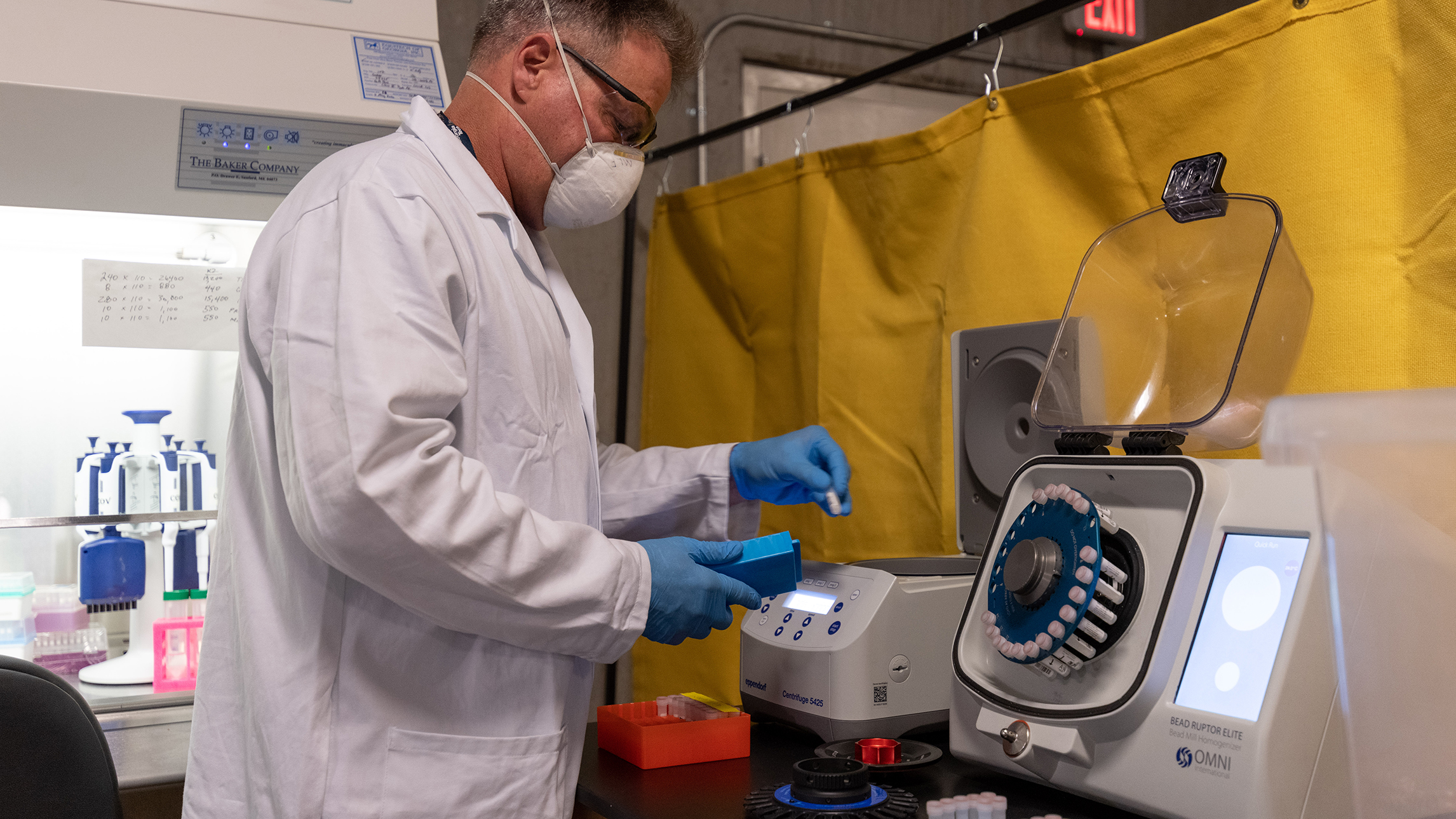 Michael Farrell, a principal research scientist at the Georgia Tech Research Institute, places vials into a Bioruptor device used to liquify saliva samples for testing. (Credit: Rob Felt, Georgia Tech)