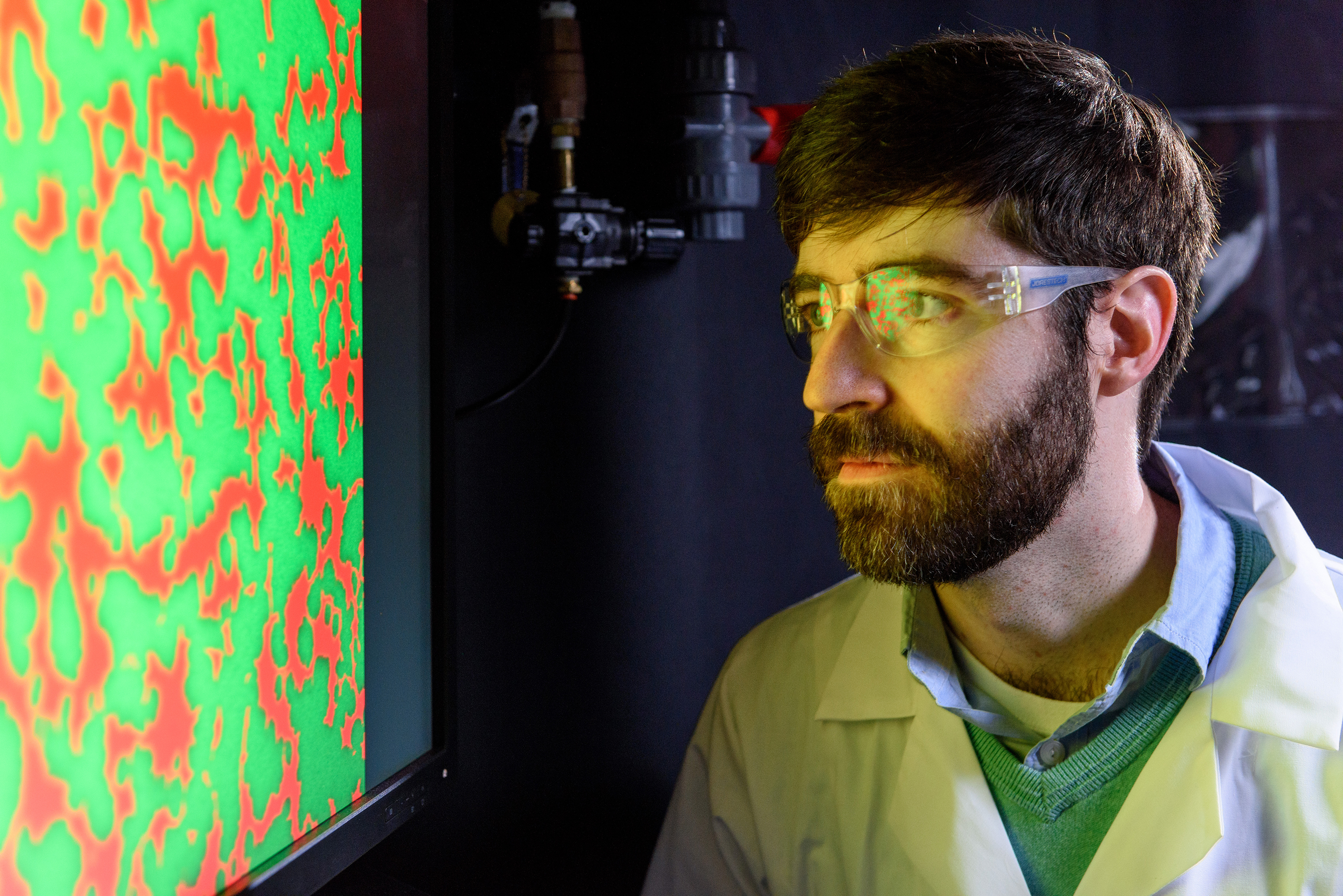 Principal investigator Peter Yunker in a photo for an unrelated experiment. Here, Yunker is looking at an image for a study on changes in territorial divisions caused by dueling strains of cholera bacteria. Credit: Rob Felt / Georgia Tech