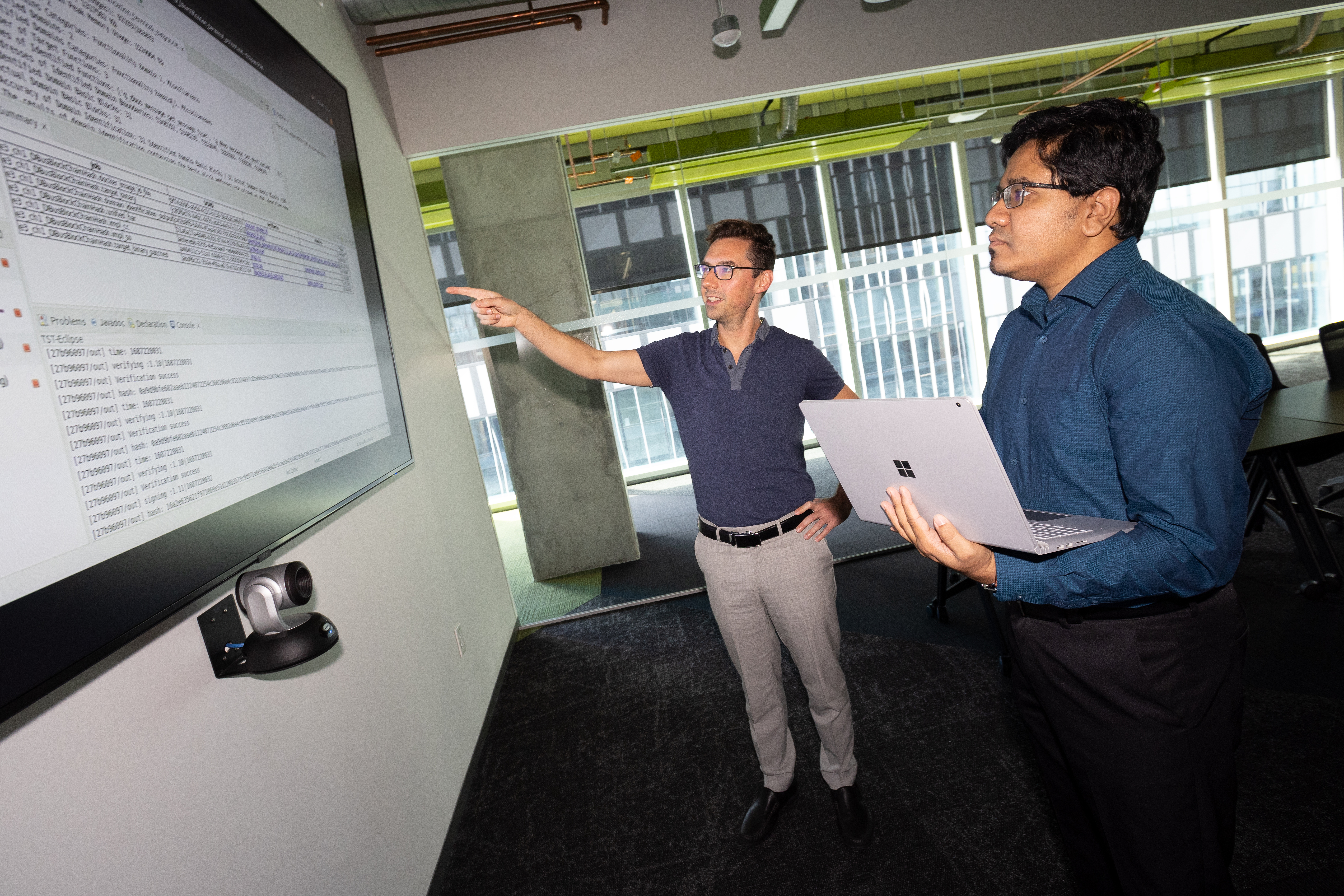 Brendan Saltaformaggio, left, and Amit Sikder are working on a $10 million DARPA project to unpack legacy software systems, incorporate updates, and redeploy them in weeks or months rather than years. (Photo: Candler Hobbs)
